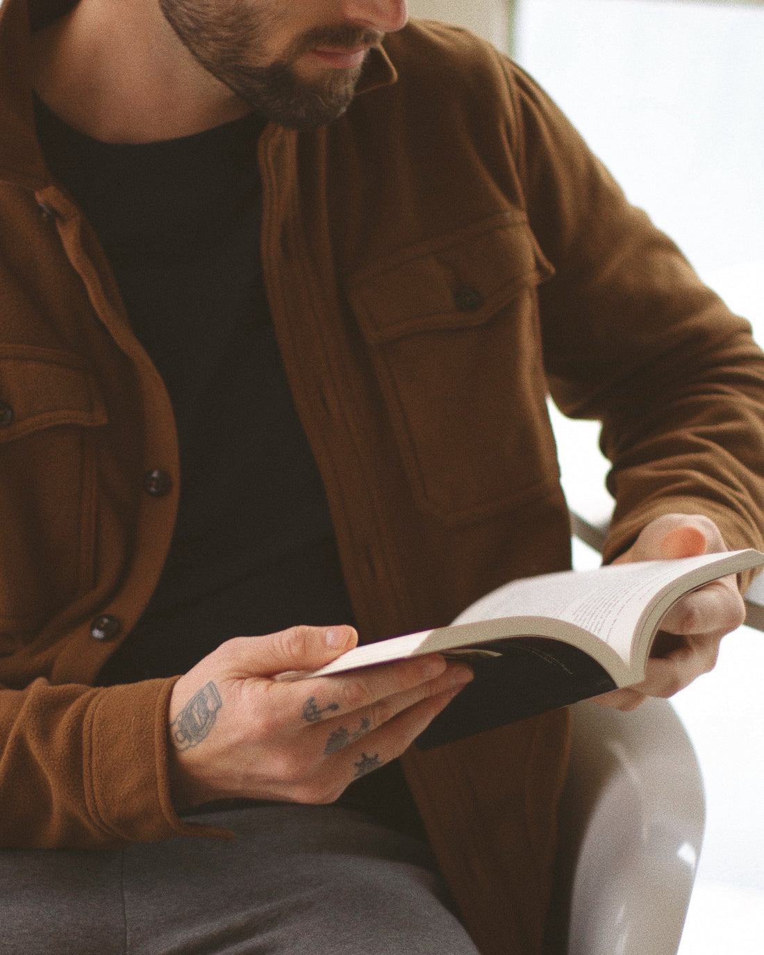man in a shirt reading a book