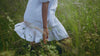 video of girl walking through grass in a dress and boots